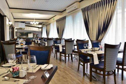 a dining room with tables and chairs and windows at Cumberland Hotel Worcester in Worcester