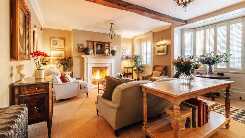 a living room with a table and a fireplace at Singer House in Chipping Campden