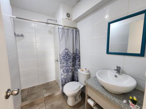 La salle de bains est pourvue d'un lavabo, de toilettes et d'un miroir. dans l'établissement Dpto acogedor con terraza privada, à Lima