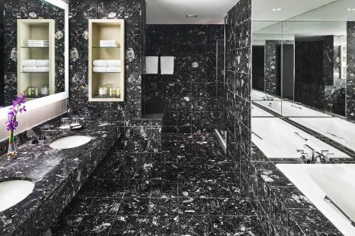 a black bathroom with two sinks and two mirrors at The Westin Chicago River North in Chicago