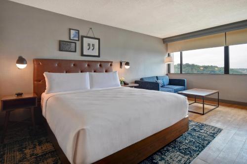 a hotel room with a large bed and a chair at Four Points by Sheraton Boston Newton in Newton