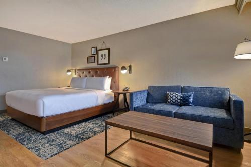 a hotel room with a bed and a couch at Four Points by Sheraton Boston Newton in Newton