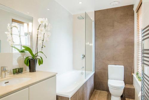 a bathroom with a toilet and a sink and a shower at Chelsea - Draycott Place by Viridian Apartments in London