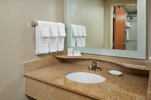 a bathroom with a sink and a mirror and towels at SpringHill Suites by Marriott Baton Rouge North / Airport in Baton Rouge
