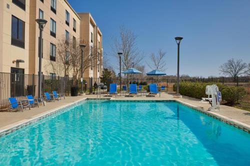 a swimming pool with blue chairs next to a building at SpringHill Suites by Marriott Baton Rouge North / Airport in Baton Rouge