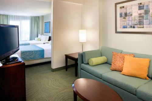 um quarto de hotel com um sofá e uma cama em SpringHill Suites Los Angeles LAX/Manhattan Beach em Hawthorne