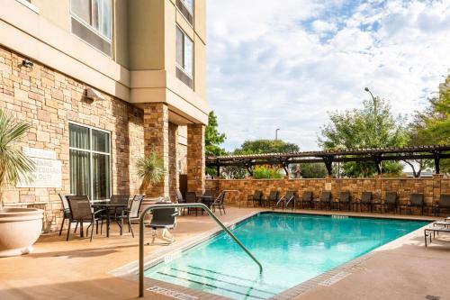 einen Pool in einem Hotel mit Stühlen und Tischen in der Unterkunft Fairfield Inn & Suites by Marriott San Antonio Downtown/Alamo Plaza in San Antonio