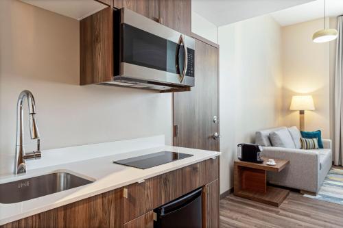 a kitchen with a sink and a microwave at Fairfield by Marriott San Jose Airport Alajuela in Alajuela
