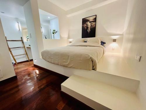 Habitación blanca con cama y espejo en Vieux-Nice : 2 pièces type loft, en Niza