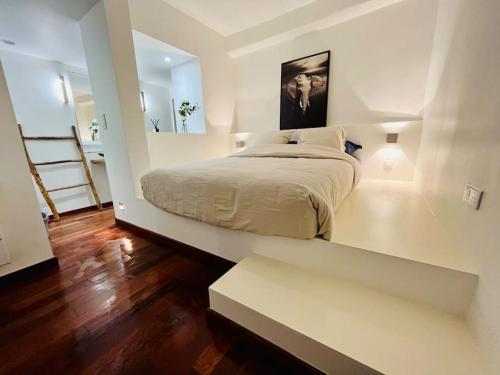 une chambre blanche avec un lit et un miroir dans l'établissement Vieux-Nice : 2 pièces type loft, à Nice