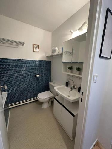 une salle de bain avec des toilettes blanches et un lavabo dans l'établissement Chez Alice, à 50m à pieds de la mer à Hardelot-Plage, à Neufchâtel-Hardelot