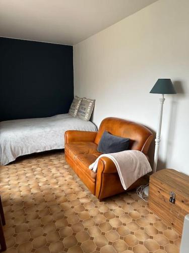 - un salon avec une chaise et un lit dans l'établissement Chez Alice, à 50m à pieds de la mer à Hardelot-Plage, à Neufchâtel-Hardelot