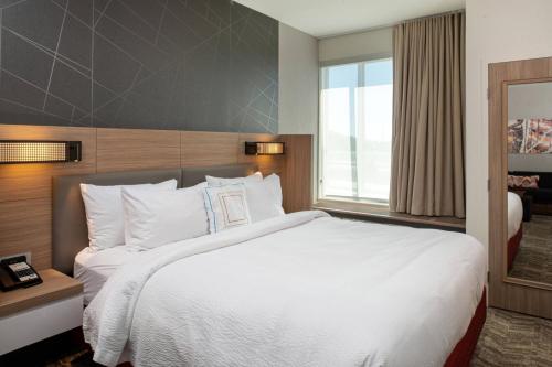 Säng eller sängar i ett rum på SpringHill Suites by Marriott Kansas City Northeast