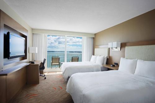 Clearwater Beach Marriott Suites on Sand Key في كليرووتر بيتش: غرفة فندقية بسريرين ونافذة كبيرة