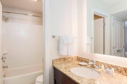 a bathroom with a sink and a toilet and a mirror at Residence Inn Boston North Shore/Danvers in Danvers