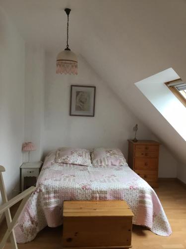 une chambre avec un lit avec un couvre-lit rose dans l'établissement B and B chambres d’hôtes 24 h du Mans et Le Mans Classic, à Sargé Les Le Mans 