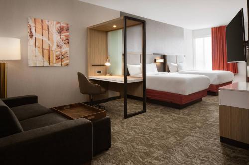 um quarto de hotel com duas camas, uma secretária e um sofá em SpringHill Suites by Marriott Ames em Ames