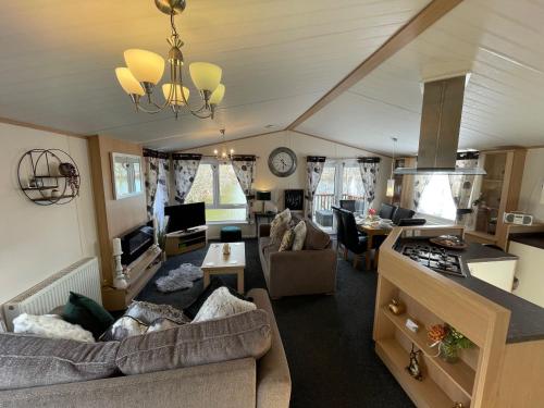 un salon avec deux canapés et une cuisine dans l'établissement Rudd lake Luxury lakeside lodge with fishing & hot tub@Tattershall, à Tattershall