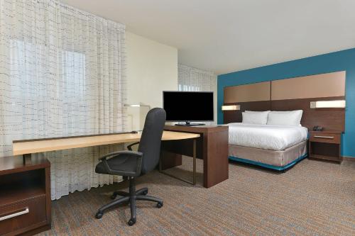a hotel room with a bed and a desk with a computer at Residence Inn by Marriott Des Moines Downtown in Des Moines