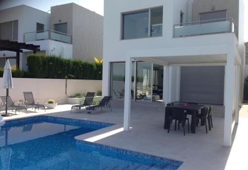 a house with a pool and a table and chairs at Modern Villa Frontline Golf in Algorfa