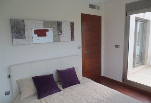 a bedroom with a bed with purple pillows and a mirror at Modern Villa Frontline Golf in Algorfa