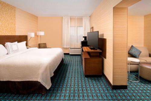 a hotel room with a bed and a chair at Fairfield Inn & Suites by Marriott Albany East Greenbush in East Greenbush