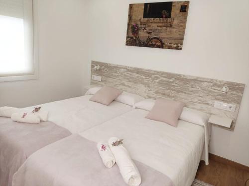 two beds in a room with white sheets and pink pillows at Gallaecia in Arzúa