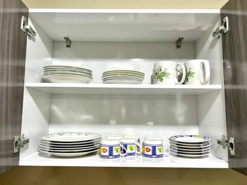 a shelf with plates and mugs and cups in a kitchen at Departamento de Patricia in Sucre
