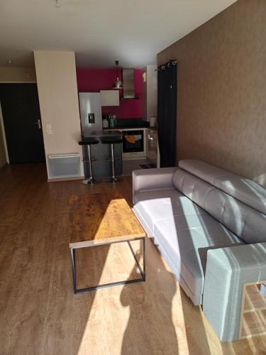 un salon avec un canapé et une table dans l'établissement Grand Appartement 2P dans immeuble PMR, à Guidel