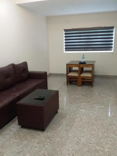 a living room with a couch and a table at Redbell suites Residency in Kondotti
