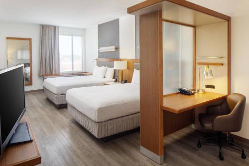 a hotel room with two beds and a desk at SpringHill Suites by Marriott Midland Odessa in Midland