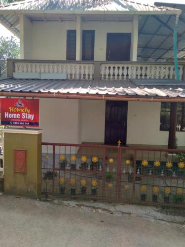 a house with a home stay sign in front of it at Homely Home stay in Kalpetta