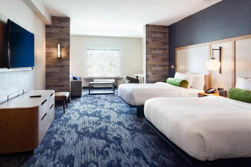 a hotel room with two beds and a desk at Fairfield Inn & Suites by Marriott Wellington-West Palm Beach in Wellington