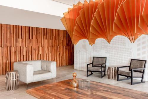 a living room with a chair and a table at Courtyard by Marriott Mexico City Vallejo in Mexico City