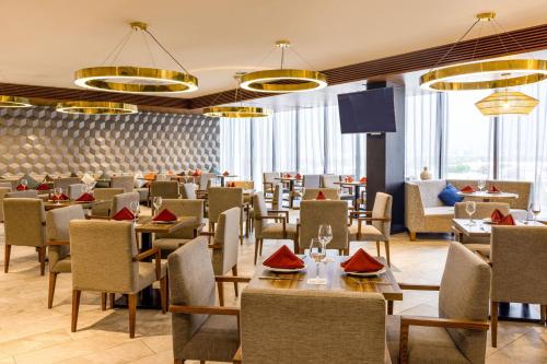 a restaurant with tables and chairs and windows at Courtyard by Marriott Mexico City Vallejo in Mexico City