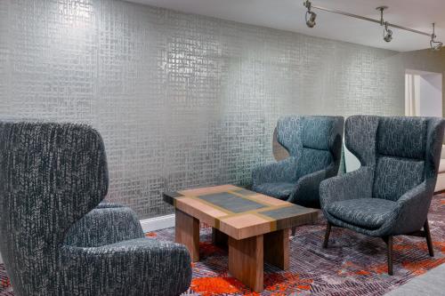 a waiting room with three chairs and a table at Courtyard by Marriott Sarasota at University Town Center in Sarasota