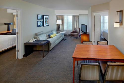 a hotel room with a couch and a bed at Residence Inn by Marriott Fort Lauderdale Weston in Weston