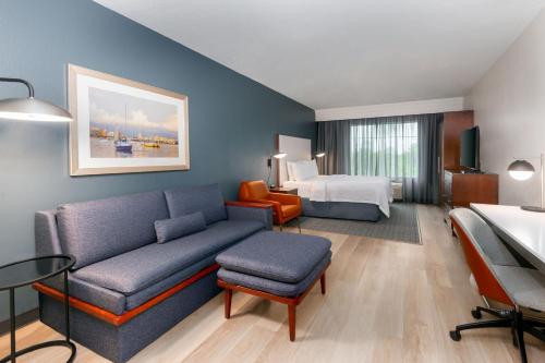 a hotel room with a couch and a bed at Courtyard by Marriott Sarasota at University Town Center in Sarasota