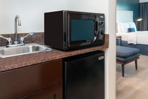 a kitchen with a microwave and a sink in a hotel room at Courtyard by Marriott Sarasota at University Town Center in Sarasota