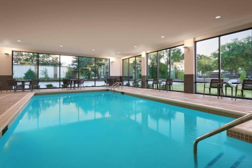 a large swimming pool with blue water in a building at Courtyard Ames in Ames