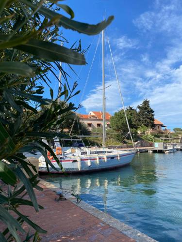 a sailboat docked at a dock in the water at Cala Reale Rooms Marinella in Marinella