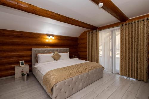 a bedroom with a large bed with wooden walls at Cold River Resort in Dorna Arini