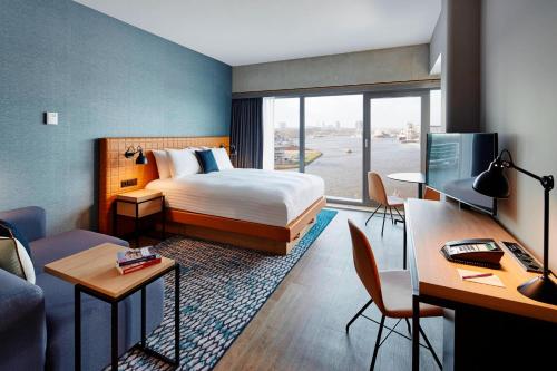 アムステルダムにあるResidence Inn by Marriott Amsterdam Houthavensのベッドとデスクが備わるホテルルームです。