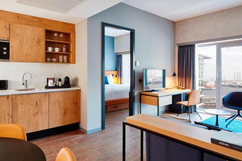 a hotel room with a kitchen and a bedroom at Residence Inn by Marriott Amsterdam Houthavens in Amsterdam