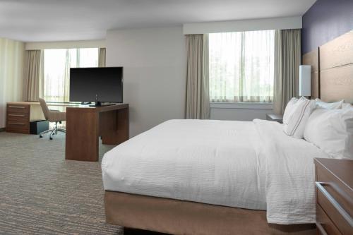 Cette chambre comprend un grand lit et un bureau. dans l'établissement Residence Inn by Marriott Virginia Beach Town Center, à Virginia Beach