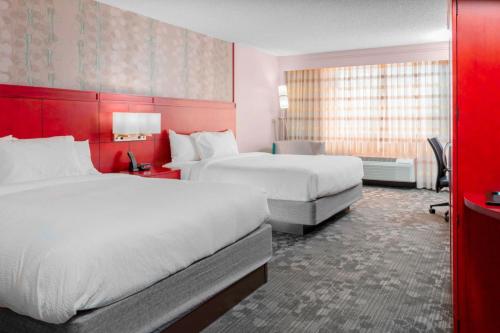 a hotel room with two beds and a red wall at Courtyard by Marriott Killeen in Killeen