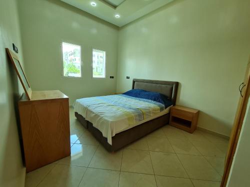 - une chambre avec un lit et une commode dans l'établissement Agreable appartement dans une résidence calme sécurisée, à Harhoura