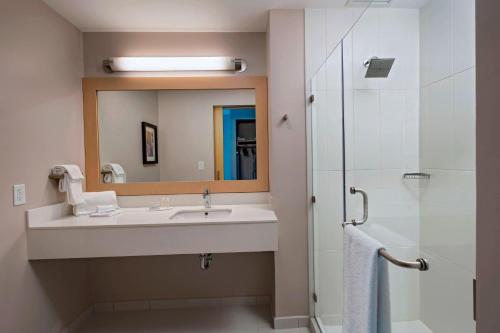 a bathroom with a sink and a mirror and a shower at Fairfield by Marriott San Salvador in San Salvador
