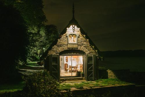 ein kleines Gebäude mit einer Uhr oben drauf in der Unterkunft The Boathouse at Old Court in Strangford