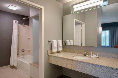 baño con lavabo y espejo grande en Courtyard Fort Lauderdale SW Miramar, en Miramar